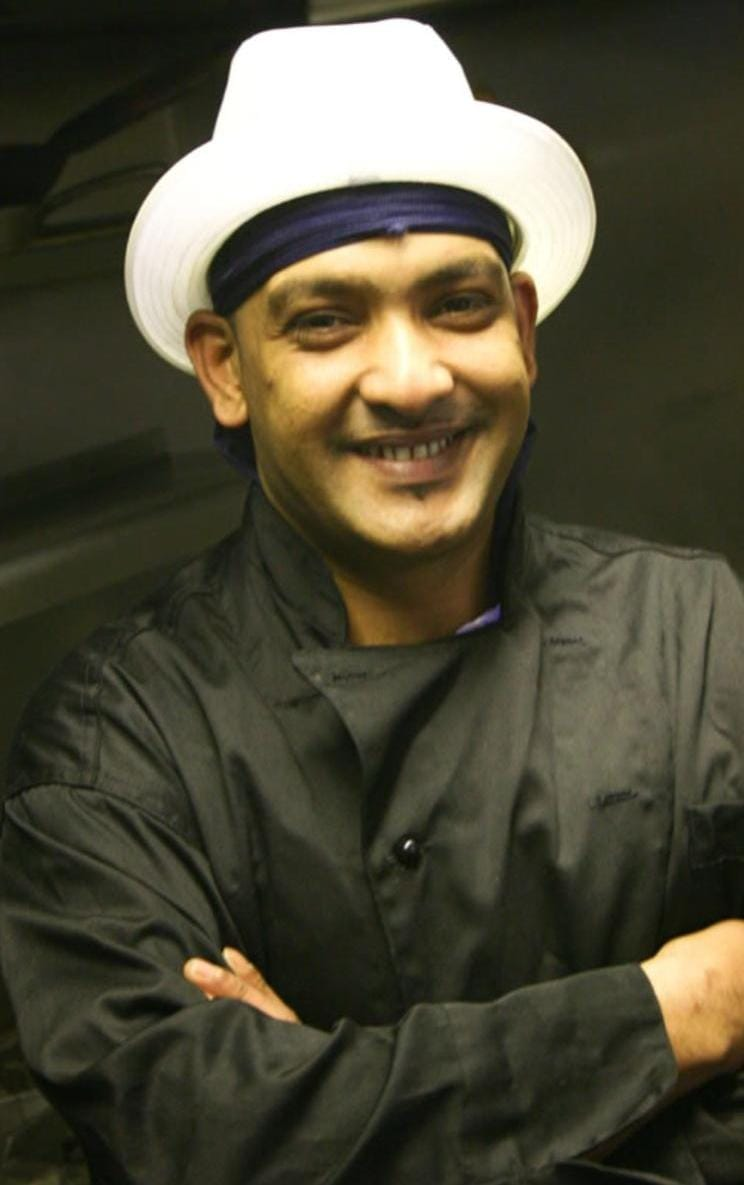 Hoque smiling in his chef’s hat